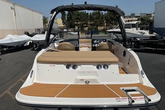 Slide: The Image of 2025 Bayliner V20i boat with tan seating and sleek design in a marina setting. - 17