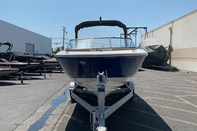 Slide: The Image of 2025 Bayliner V20i boat on trailer in outdoor storage area. - 2