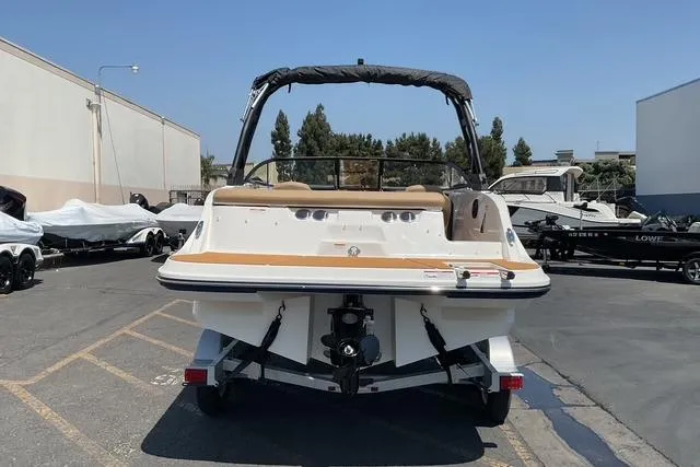 Slide: The Image of 2025 Bayliner V20i boat on trailer, parked outdoors in a marina setting. - 6