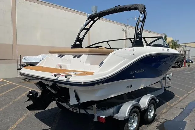 Slide: The Image of 2025 Bayliner V20i boat on trailer, parked outdoors, showcasing sleek design and modern features. - 7