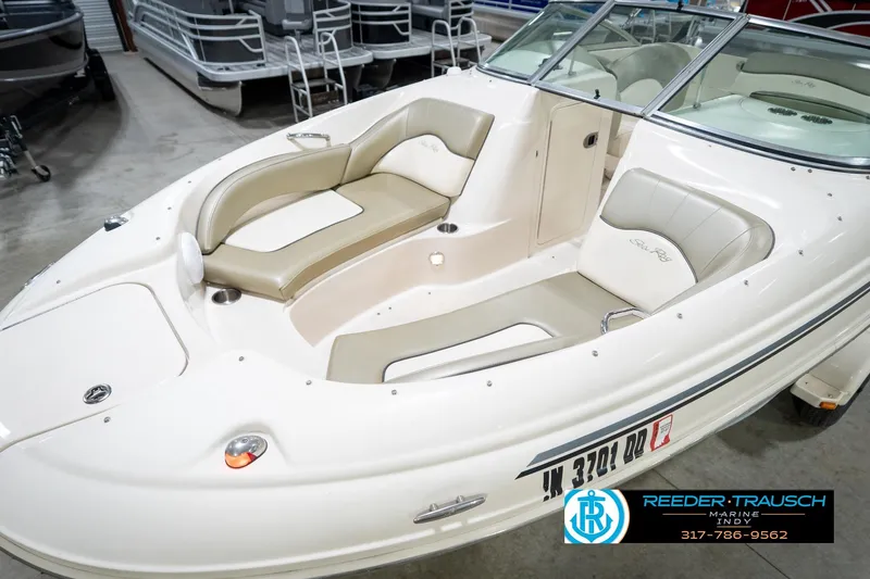 Slide: The Image of 2005 Sea Ray 200 Sundeck boat interior with beige seating, displayed at Reeder-Trausch Marine. - 13