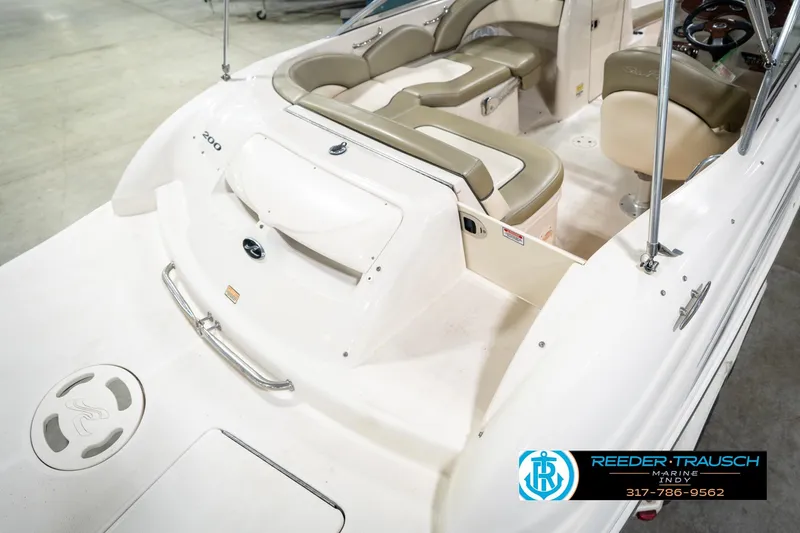 Slide: The Image of 2005 Sea Ray 200 Sundeck boat interior with beige seating and cup holders. - 14