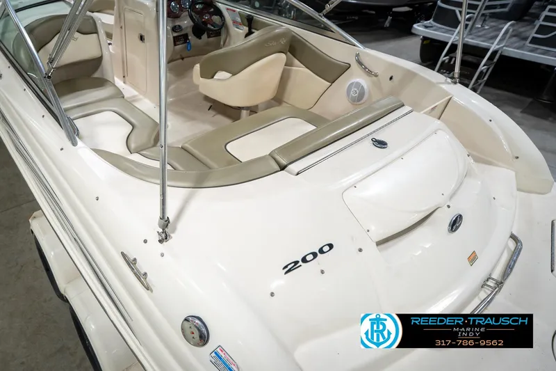 Slide: The Image of 2005 Sea Ray 200 Sundeck boat interior with beige seating and steering wheel. - 15