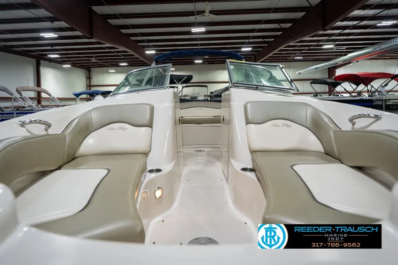 Slide: The Image of 2005 Sea Ray 200 Sundeck interior in a showroom, featuring beige seating and dashboard. - 17