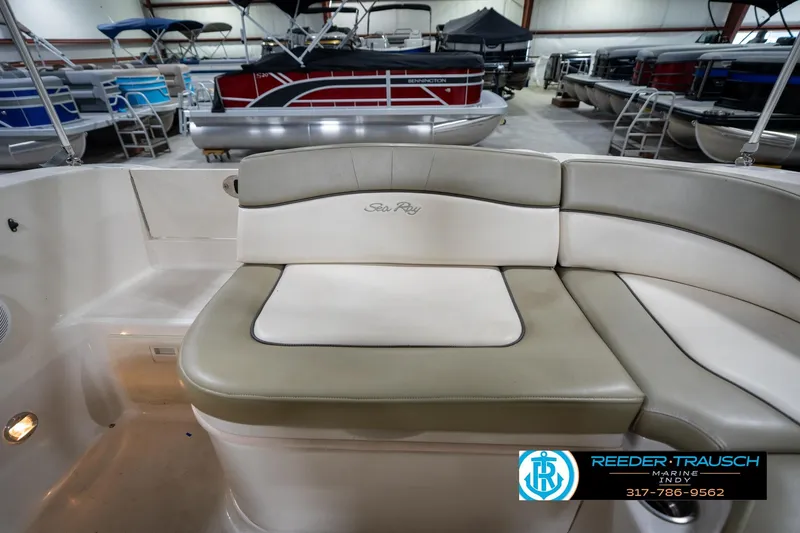 Slide: The Image of 2005 Sea Ray 200 Sundeck interior with beige seating and cup holders in a garage. - 19
