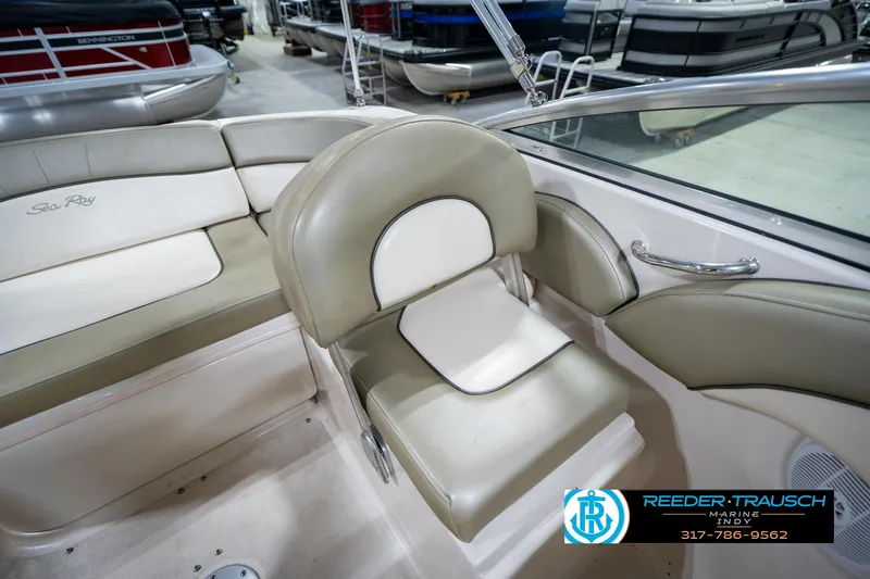 Slide: The Image of 2005 Sea Ray 200 Sundeck interior with seating and cup holders in a garage setting. - 24