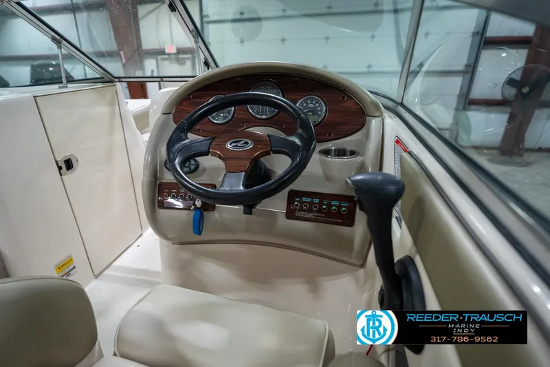Slide: The Image of 2005 Sea Ray 200 Sundeck interior seating with beige upholstery and logo. - 26