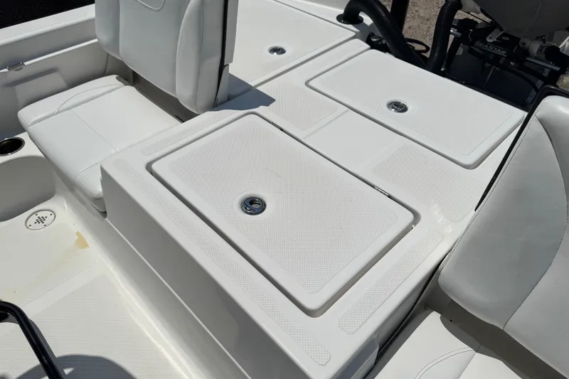 Slide: The Image of 2017 Epic 22 Sport Console boat interior with white seating and storage compartments. - 17