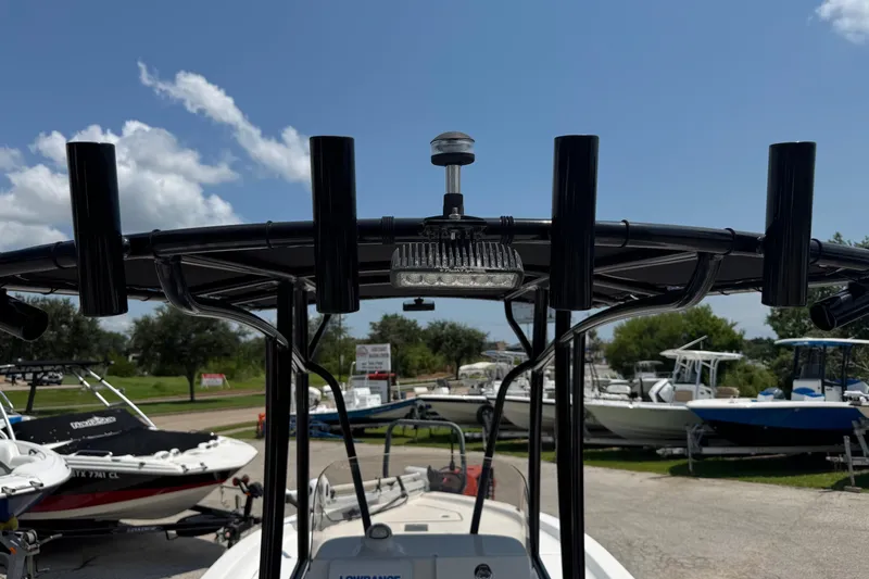 Slide: The Image of 2017 Epic 22 Sport Console boat with rod holders and light, parked outdoors. - 21