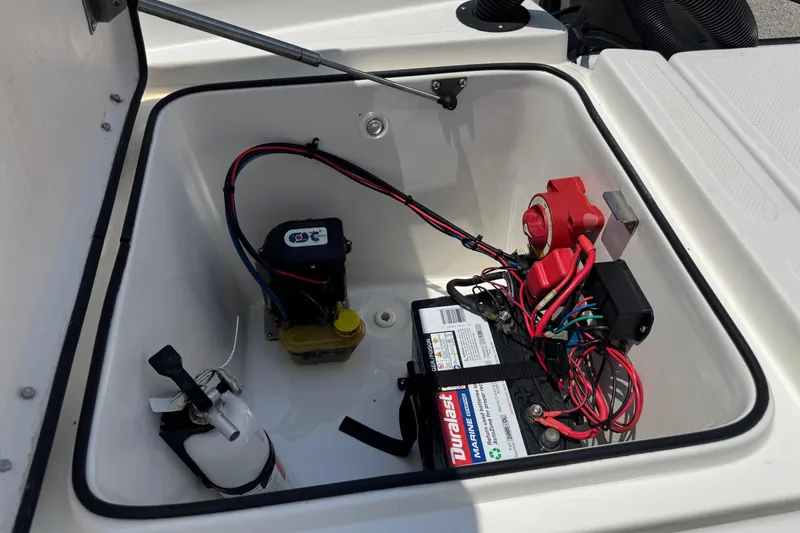 Slide: The Image of 2017 Epic 22 Sport Console boat battery compartment with wiring and fire extinguisher. - 24