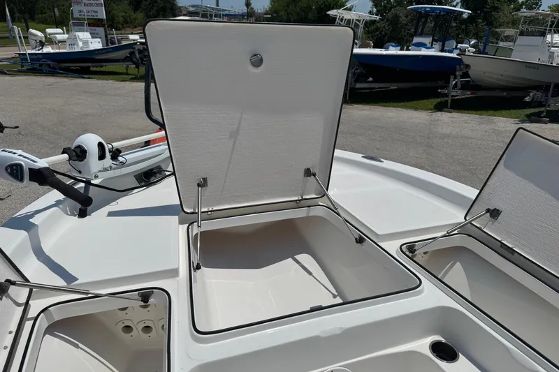 Slide: The Image of 2017 Epic 22 Sport Console boat with open storage compartments and trolling motor. - 28