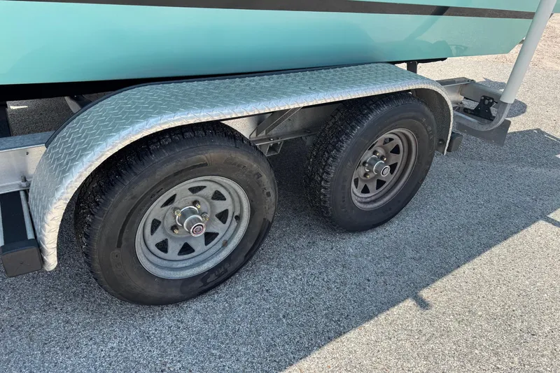 Slide: The Image of Trailer wheels of a 2017 Epic 22 Sport Console boat on pavement. - 3