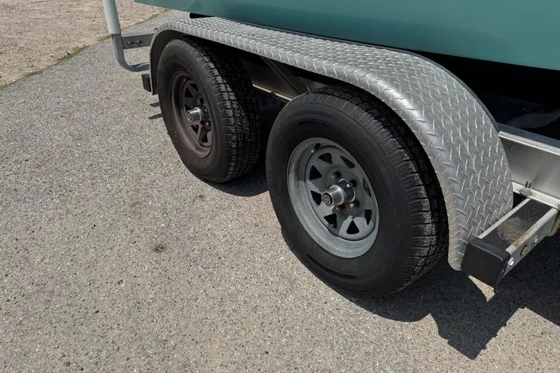 Slide: The Image of Trailer wheels of a 2017 Epic 22 Sport Console boat on pavement. - 7