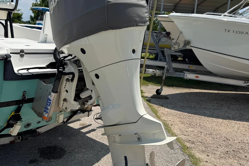 Slide: The Image of 2017 Epic 22 Sport Console boat with covered outboard motor in a marina setting. - 9