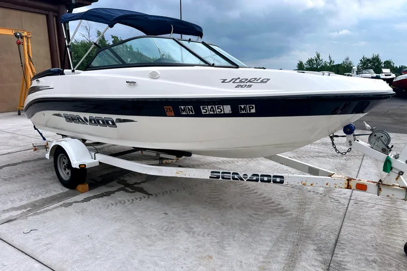 Slide: The Image of 2003 Sea-Doo Utopia 185 boat on trailer, parked outdoors under cloudy sky. - 10