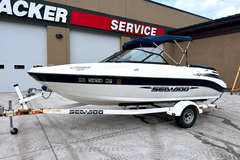 Slide: The Image of 2003 Sea-Doo Utopia 185 boat on trailer, parked outside service center. - 11