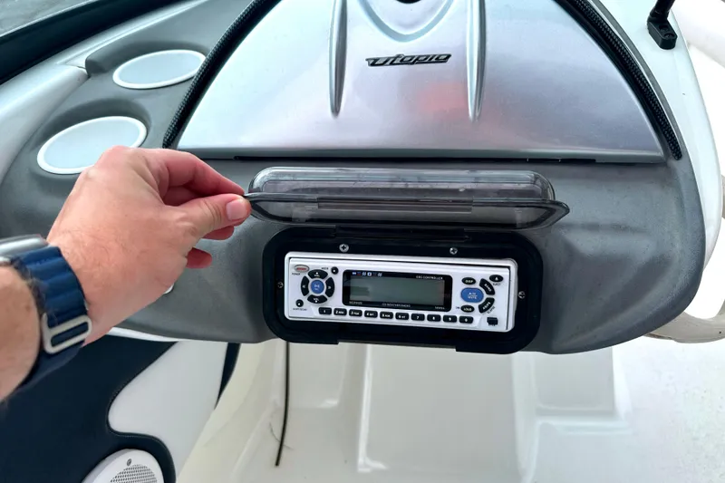 Slide: The Image of Dashboard of 2003 Sea-Doo Utopia 185 boat with stereo system and hand adjusting cover. - 17
