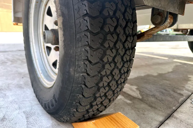 Slide: The Image of Close-up of a 2003 Sea-Doo Utopia 185 trailer tire on a wooden block. - 22
