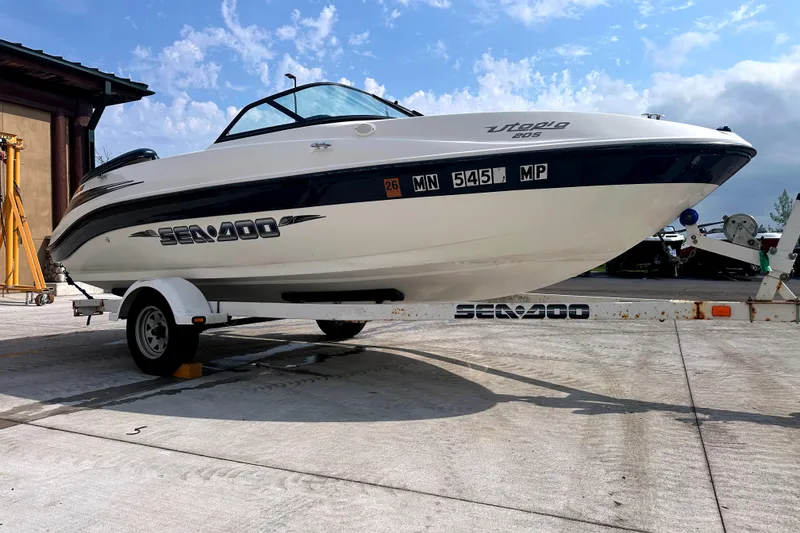 Slide: The Image of 2003 Sea-Doo Utopia 185 boat on trailer, parked outdoors under a blue sky. - 3