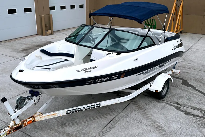 Slide: The Image of 2003 Sea-Doo Utopia 185 boat on trailer, parked in front of garage doors. - 4