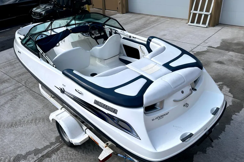 Slide: The Image of 2003 Sea-Doo Utopia 185 boat on trailer, white with blue accents, parked outdoors. - 5