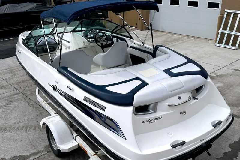 Slide: The Image of 2003 Sea-Doo Utopia 185 boat with blue canopy on trailer, parked outdoors. - 6