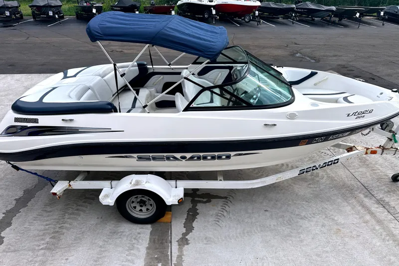 Slide: The Image of 2003 Sea-Doo Utopia 185 boat with blue canopy on trailer, parked outdoors. - 9
