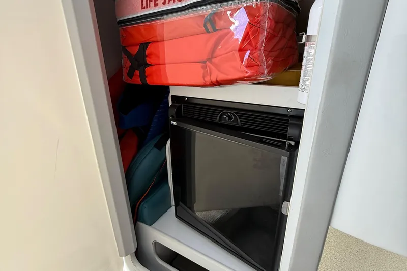 Slide: The Image of Storage compartment in a 1995 Formula 382 SR-1 boat with life jackets and a mini fridge. - 12