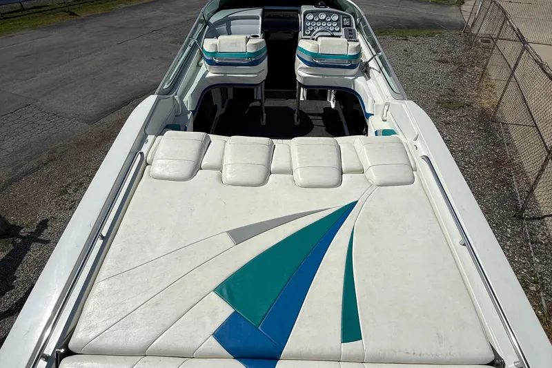 Slide: The Image of 1995 Formula 382 SR-1 boat with white and teal seating, docked on pavement. - 24