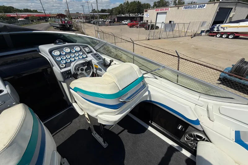Slide: The Image of 1995 Formula 382 SR-1 boat cockpit with steering wheel and gauges, parked near fiberglass shop. - 26