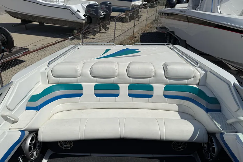 Slide: The Image of 1995 Formula 382 SR-1 boat interior with white and blue seating, docked near other boats. - 32