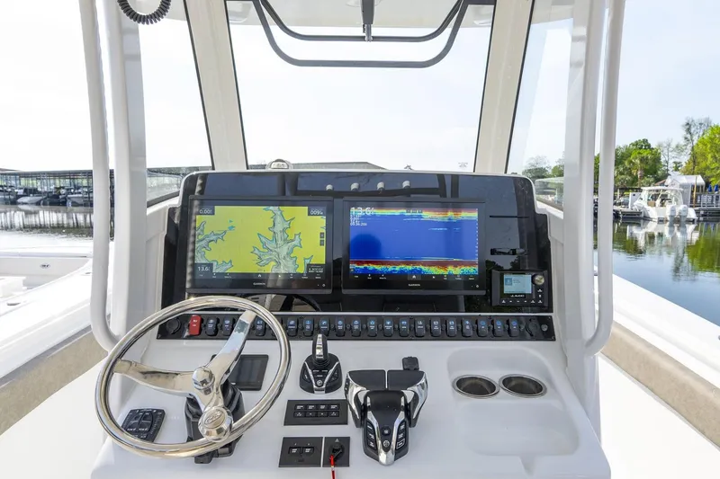 Slide: The Image of 2026 Sea Hunt Ultra 229 boat interior with white cushioned seating and storage compartments. - 8