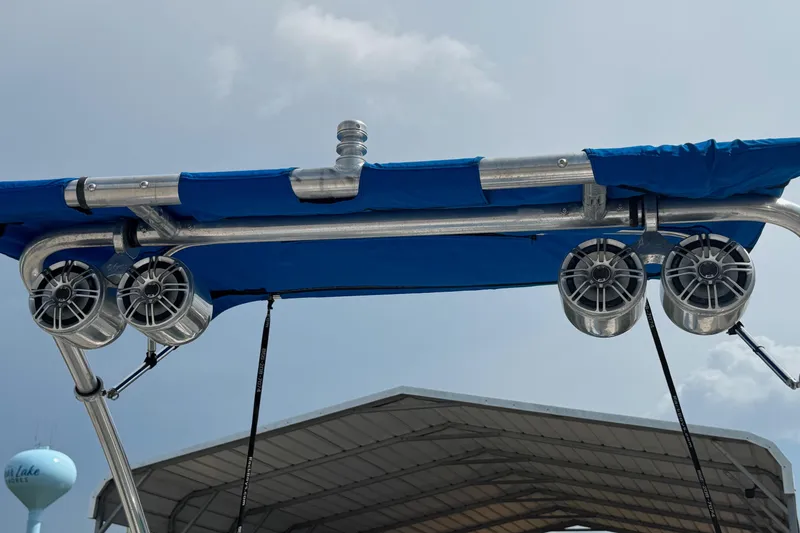 Slide: The Image of 2007 Sea Ray 195 Sport boat speakers and blue canopy under a cloudy sky. - 7