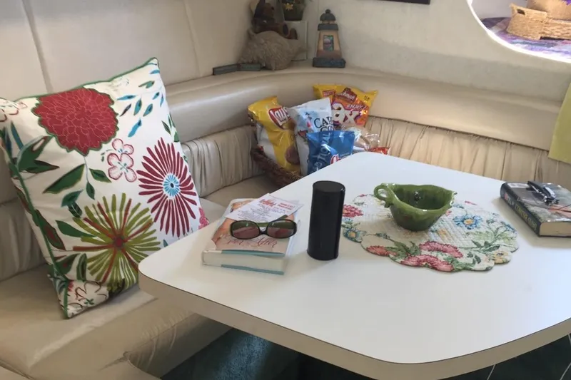 Slide: The Image of Interior of 1993 Silverton 34 Express with table, floral pillow, snacks, and books. - 5