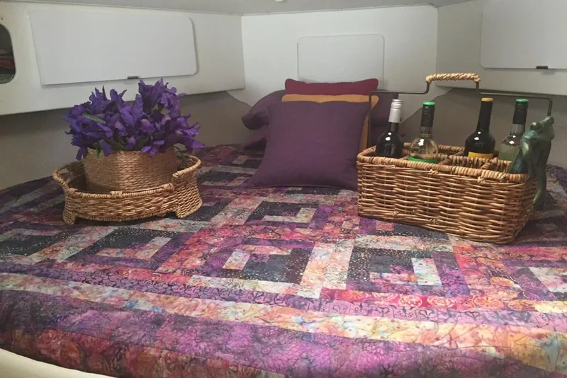 Slide: The Image of Cozy cabin interior of 1993 Silverton 34 Express with vibrant quilt and wicker baskets. - 7