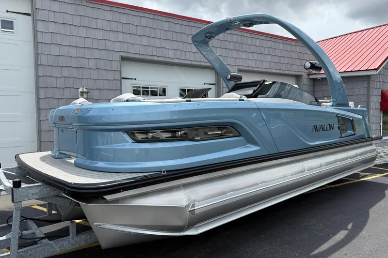 Slide: The Image of 2026 Avalon 2585 Excalibur Tri-toon boat with Mercury 400hp V-10 engine, parked outdoors. - 1