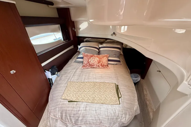 Slide: The Image of Cozy bedroom interior of 2014 Meridian 391 Sedan yacht with striped pillows and wooden accents. - 34