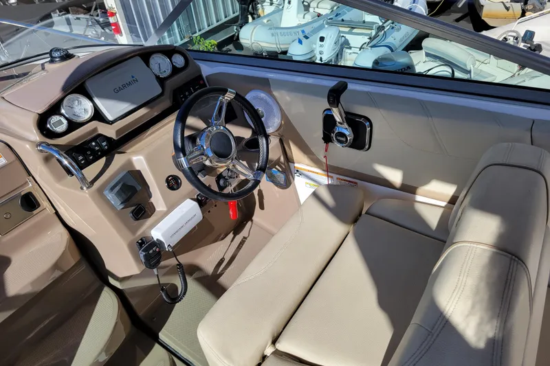 Slide: The Image of 2018 Regal 26 Express boat cockpit with Garmin navigation and beige seating. - 11