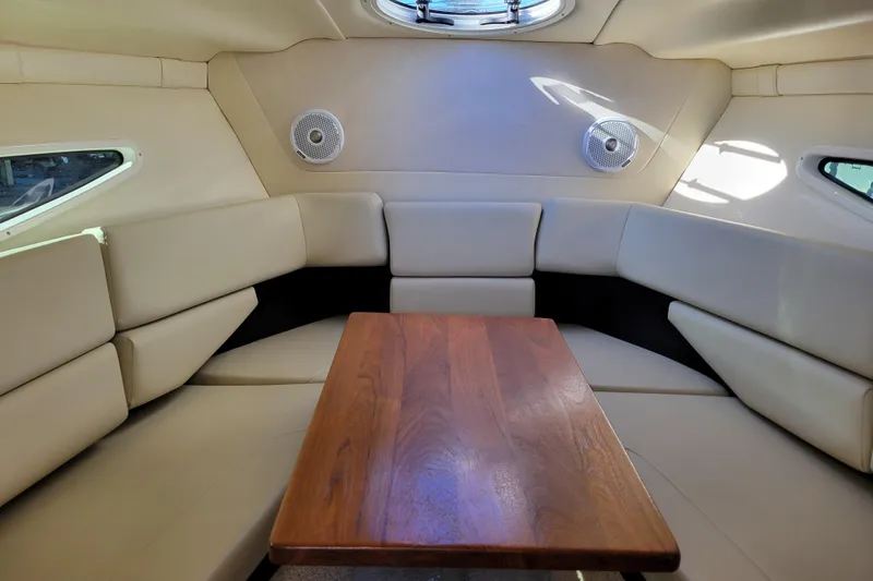 Slide: The Image of Interior of 2018 Regal 26 Express boat with beige seating and wooden table. - 22
