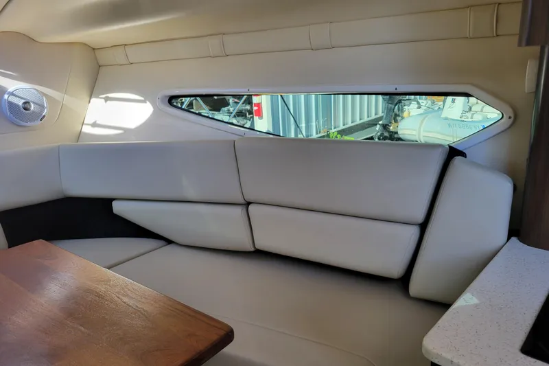 Slide: The Image of Interior of 2018 Regal 26 Express boat with beige seating and wooden table. - 23