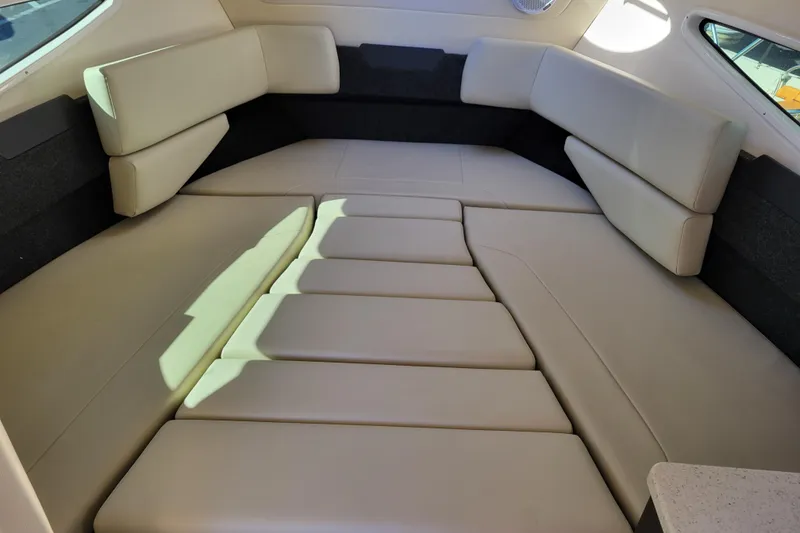 Slide: The Image of Interior of 2018 Regal 26 Express boat with beige seating and wooden table. - 24