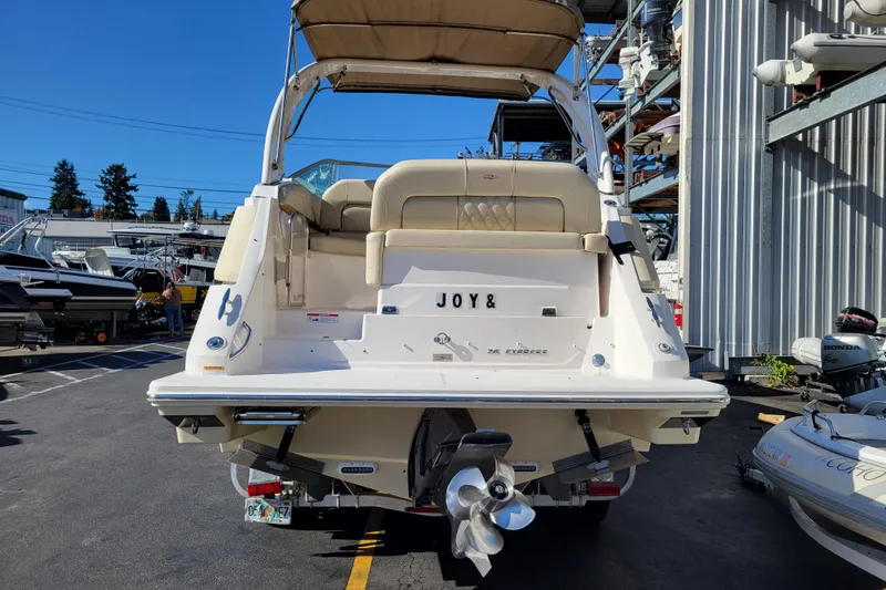 Slide: The Image of 2018 Regal 26 Express boat docked, rear view with "JOY&" nameplate. - 3