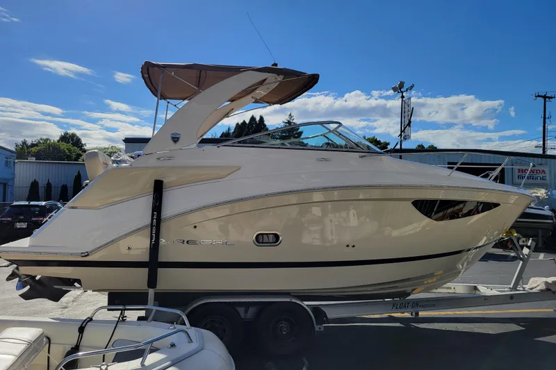 Slide: The Image of 2018 Regal 26 Express boat on trailer under clear blue sky. - 4