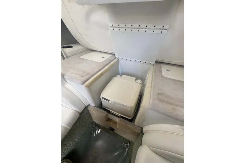 Slide: The Image of 2005 Formula 292 FASTech boat interior with compact portable toilet and cushioned seating. - 13