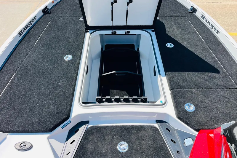 Slide: The Image of 2025 Ranger Z520 boat deck with open storage compartment, black carpet, and sleek design. - 15