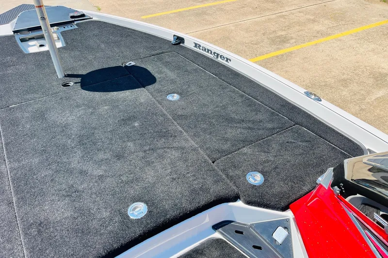 Slide: The Image of 2025 Ranger Z520 boat deck with carpeted surface and storage compartments. - 17