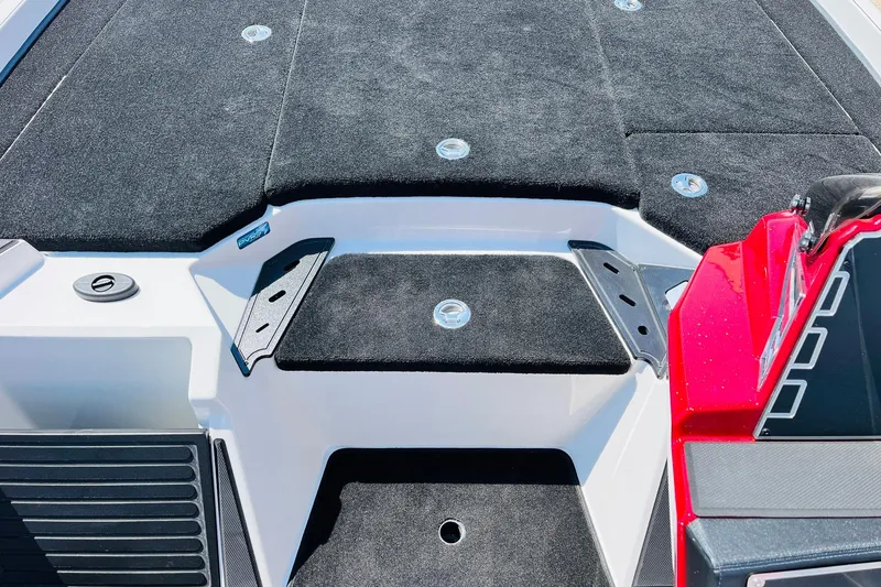 Slide: The Image of 2025 Ranger Z520 boat deck with black carpet and red accents. - 22