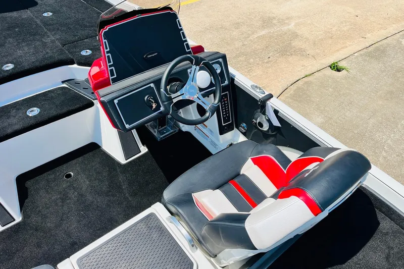 Slide: The Image of 2025 Ranger Z520 boat cockpit with steering wheel and red-black seat. - 31