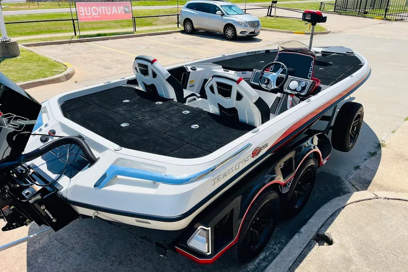 Slide: The Image of 2025 Ranger Z520 boat with sleek design, dual seats, and advanced dashboard in a parking lot. - 5