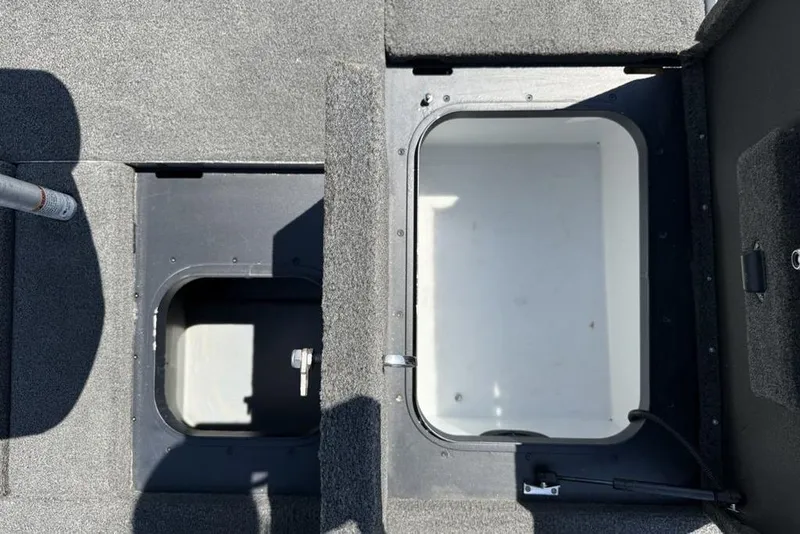 Slide: The Image of 2014 Skeeter FX 20 boat storage compartments, open and empty, with carpeted surfaces. - 24